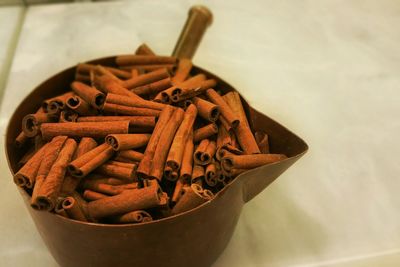 High angle view of cinnamon sticks in bowl on table