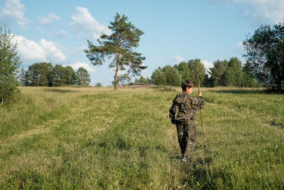 Boy in field against sky