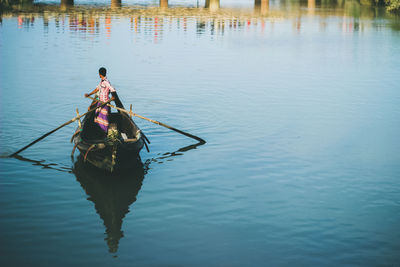 Rear view of man sitting in lake