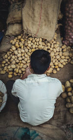 Rear view of woman sitting at market stall