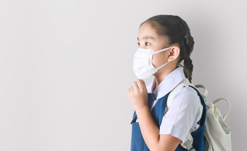 Portrait of girl standing against white background