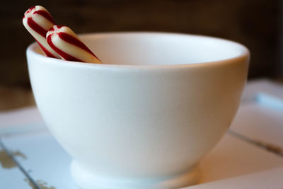 Close-up of candy canes in bowl on table