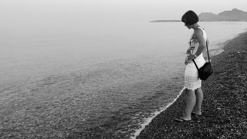 Side view of woman standing at beach