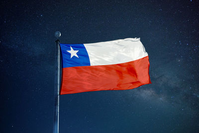 Low angle view of flag against blue sky