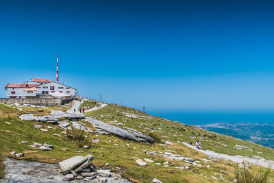 Scenic view of sea by buildings against clear blue sky