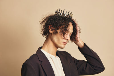 Portrait of young man standing against gray background