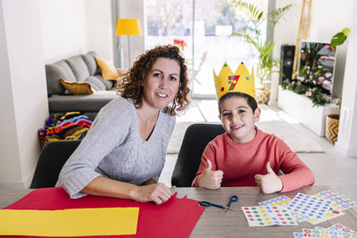 Mother and son making crafts at home with cardstocks and stickers