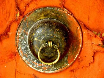 Close-up of metal hook on orange wall