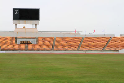 Empty chairs in stadium against sky