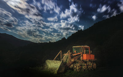 Abandoned cars on field against sky