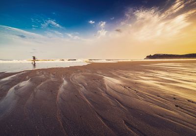 Beach against cloudy sky