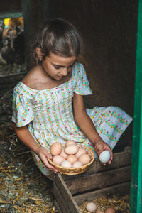 Cute girl holding eggs in basket