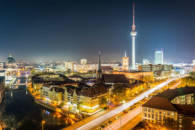 Illuminated fernsehturm and cityscape against sky at night