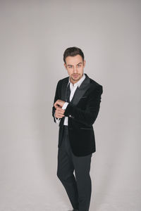 Portrait of young man standing against white background