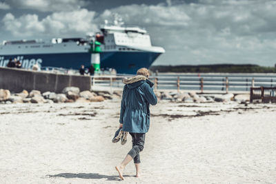 Rear view of man walking on beach