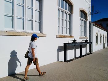 Side view of man walking against building