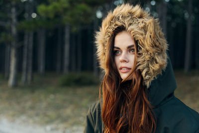 Young woman wearing fur hat while standing outdoors