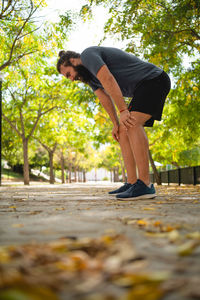 Man standing by tree trunk