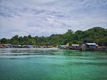 Scenic view of river by buildings against sky