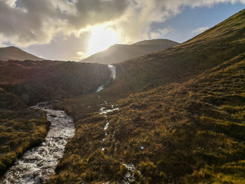 Scenic view of river amidst mountains against sky