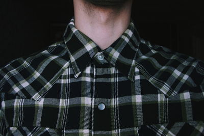 Midsection of man wearing checked pattern shirt