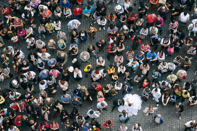 High angle view of married couple standing in crowd on footpath