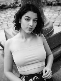 Portrait of young woman sitting outdoors