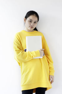 Portrait of woman standing against white background