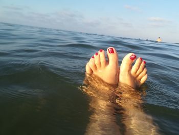 Low section of woman relaxing in sea