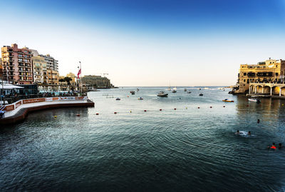 Boat in sea by buildings 