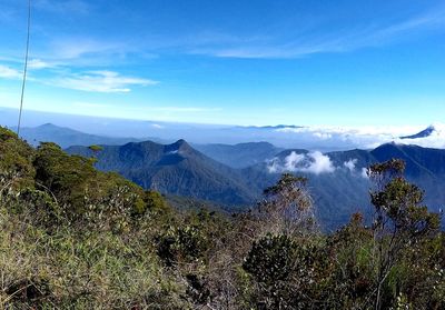 Scenic view of mountains against blue sky
