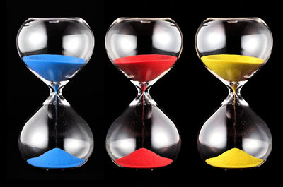 Close-up of hourglass on black background