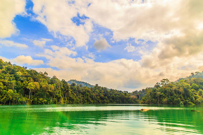 Scenic view of lake by trees against sky