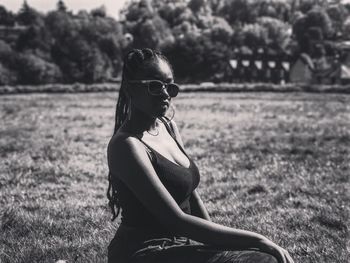 Portrait of woman wearing sunglasses sitting at park