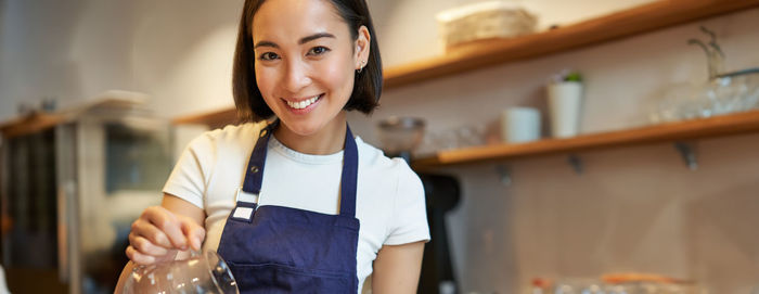 Portrait of young woman standing at home