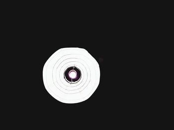 Low angle view of illuminated light bulb against black background