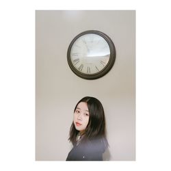 Portrait of woman standing against wall