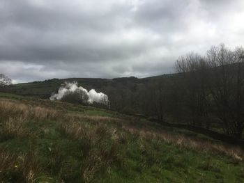 Scenic view of landscape against storm clouds