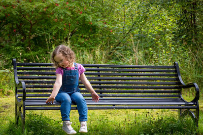Full length of girl sitting on bench