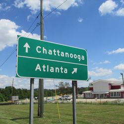 Road sign against cloudy sky