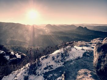 Rocky mountain peak with snow and sky with hot sun in winter, winter landscape