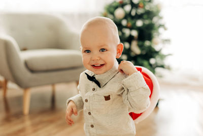 Portrait of a cute smiling baby on the background of a christmas tree on the eve of celebrating