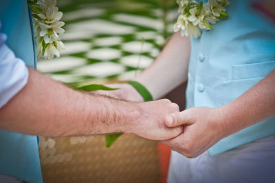 Midsection of couple holding hands