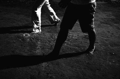 Low section of woman walking on road