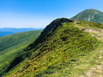 Scenic view of mountains against clear blue sky