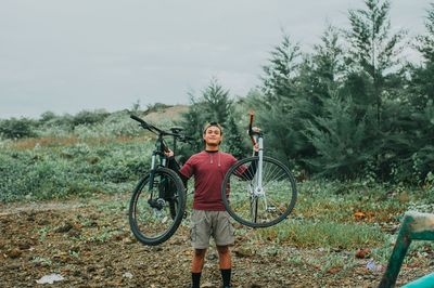 Portrait of man with bicycle on field