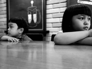 Portrait of cute girl sitting on hardwood floor at home