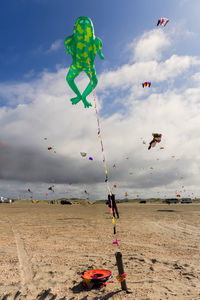 Kits flying over beach against sky