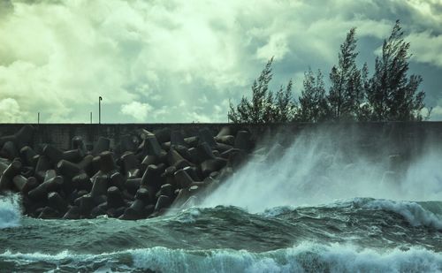 Panoramic shot of rocks in sea against sky