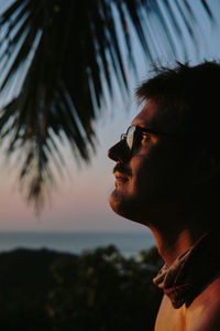 Close-up of young man wearing sunglasses against sky